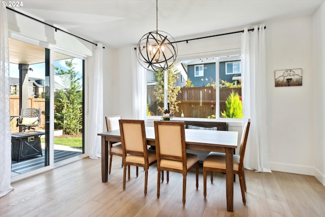 dining room featuring a wealth of natural light, light hardwood / wood-style flooring, and a notable chandelier