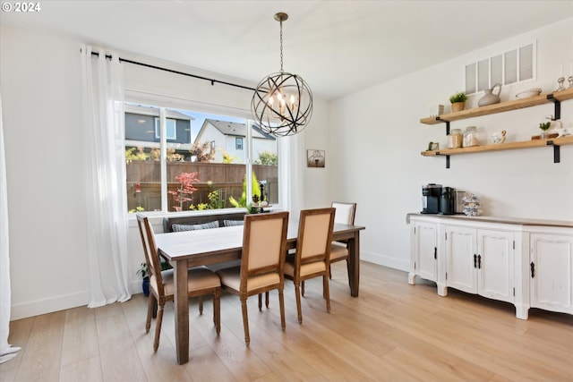 dining area with a notable chandelier and light hardwood / wood-style floors