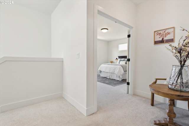 hallway featuring light colored carpet