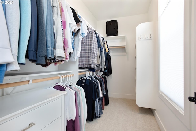 walk in closet with light carpet