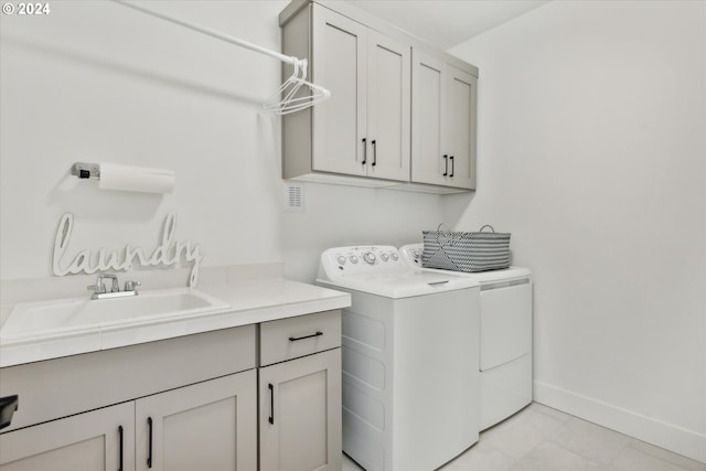 laundry room featuring sink, cabinets, and separate washer and dryer