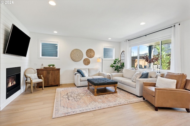 living room with light hardwood / wood-style floors and a fireplace