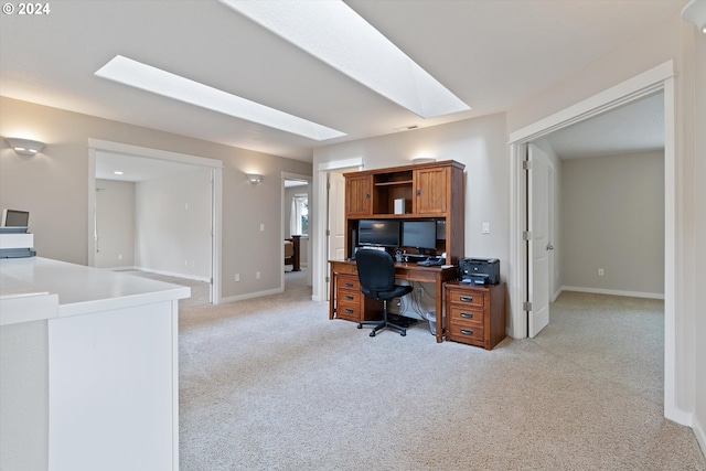 carpeted home office featuring a skylight