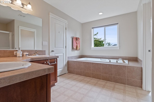 bathroom with vanity and tiled tub