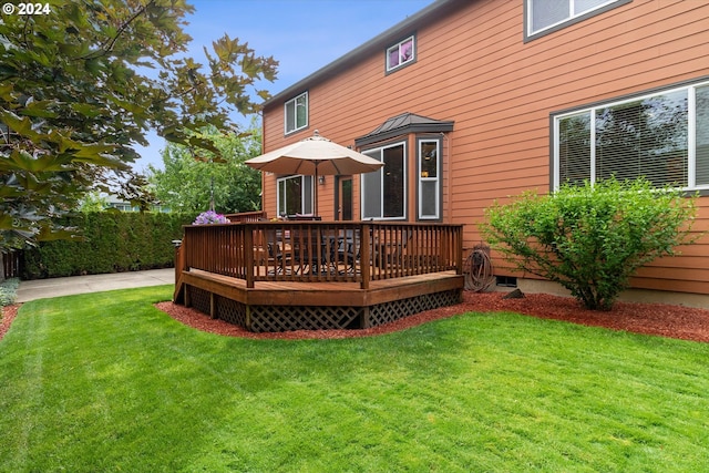 rear view of property featuring a wooden deck and a yard