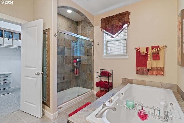 bathroom featuring tile patterned flooring and separate shower and tub