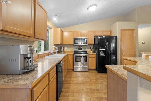 kitchen featuring black appliances, a textured ceiling, sink, vaulted ceiling, and light hardwood / wood-style floors