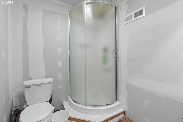 bathroom with toilet and a shower with door