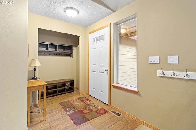 mudroom featuring a textured ceiling and light wood-type flooring