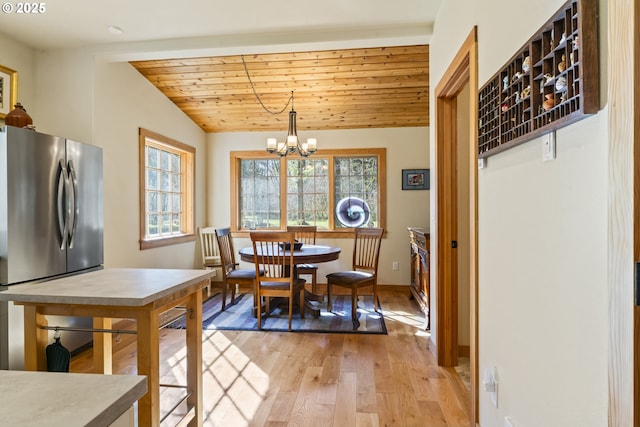 dining space featuring light wood-style flooring, an inviting chandelier, baseboards, wood ceiling, and vaulted ceiling