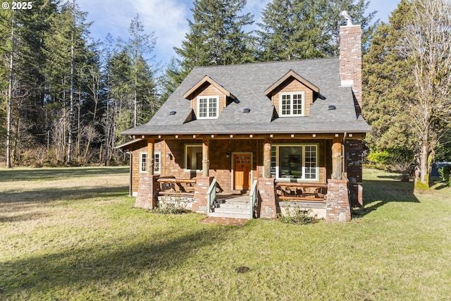 view of front of house with a porch, a chimney, and a front yard