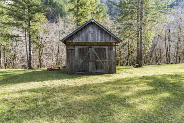 view of outbuilding featuring an outdoor structure and a wooded view