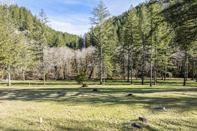 view of home's community featuring a lawn and a view of trees