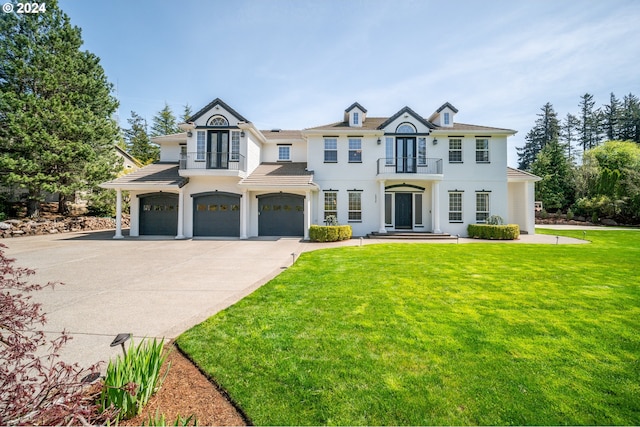 view of front of property featuring a garage, a front lawn, and a balcony