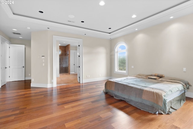 bedroom with a raised ceiling and hardwood / wood-style flooring