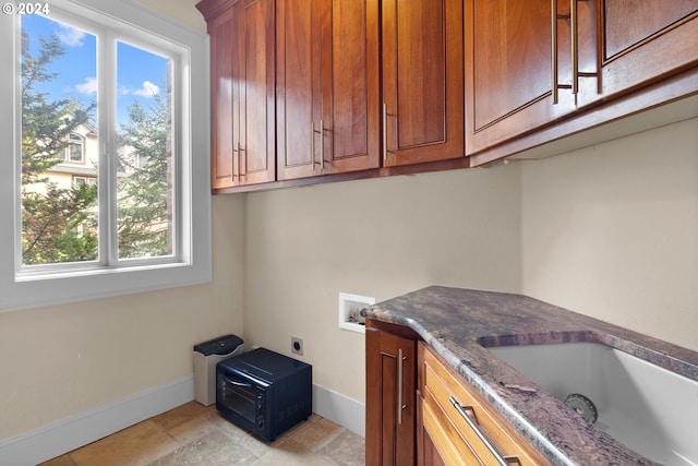 laundry area with a healthy amount of sunlight, cabinets, light tile floors, and hookup for a washing machine