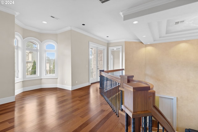 hallway with dark hardwood / wood-style flooring, a healthy amount of sunlight, a tray ceiling, and crown molding