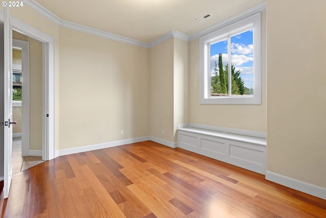 unfurnished room with ornamental molding and light hardwood / wood-style flooring