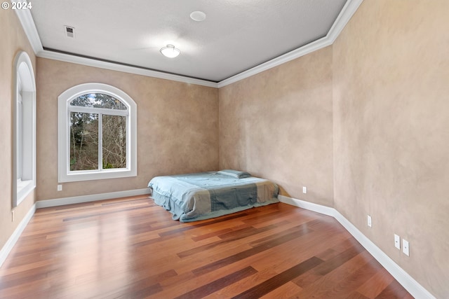 bedroom featuring light hardwood / wood-style floors and crown molding