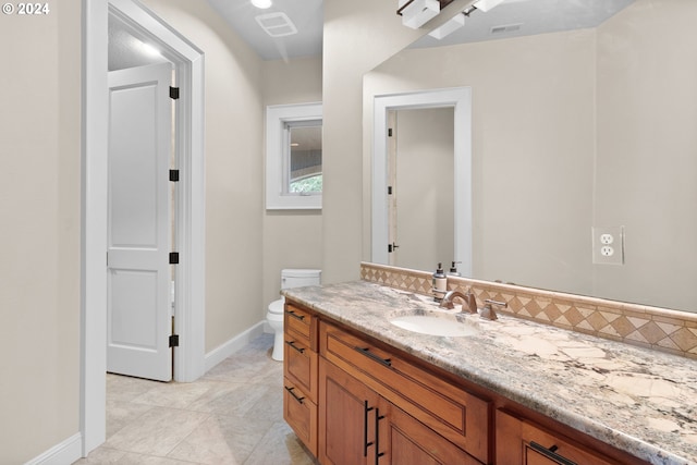 bathroom featuring toilet, tile flooring, and large vanity