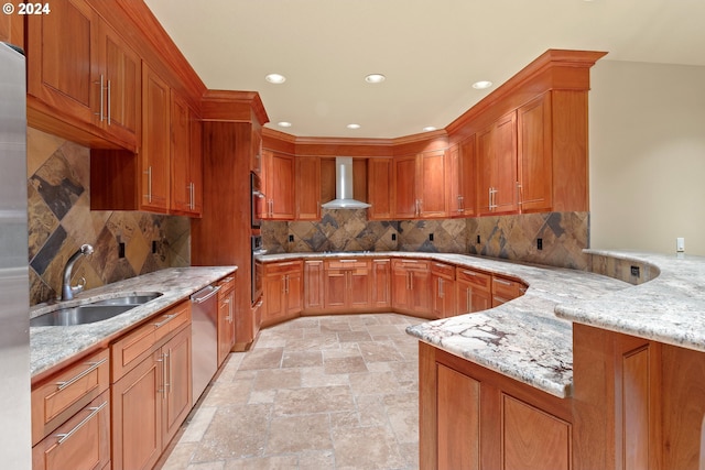 kitchen featuring wall chimney exhaust hood, sink, backsplash, and light stone countertops