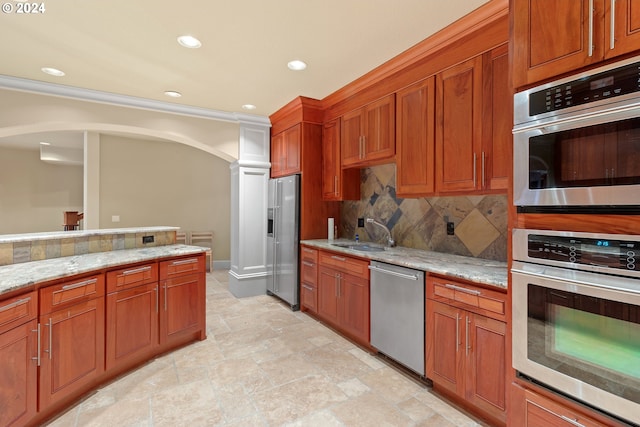 kitchen featuring light stone countertops, appliances with stainless steel finishes, sink, light tile floors, and tasteful backsplash