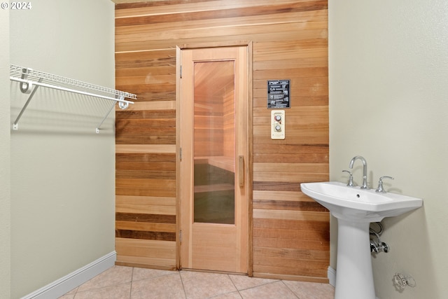 bathroom featuring tile flooring and wooden walls