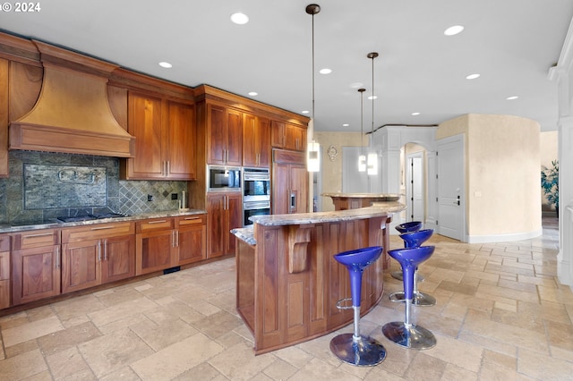 kitchen featuring built in appliances, custom range hood, decorative light fixtures, and light tile flooring