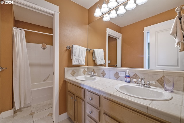 bathroom with tasteful backsplash, shower / bathtub combination with curtain, dual bowl vanity, and tile patterned floors