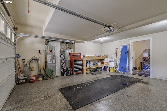 garage with a workshop area, secured water heater, and a garage door opener