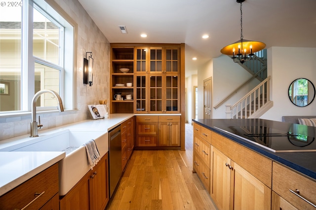 kitchen featuring sink, decorative light fixtures, a chandelier, a center island, and light hardwood / wood-style floors