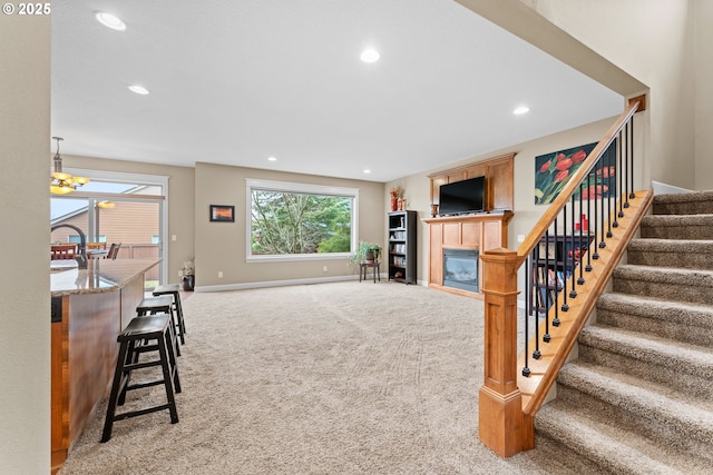 carpeted living room with a chandelier