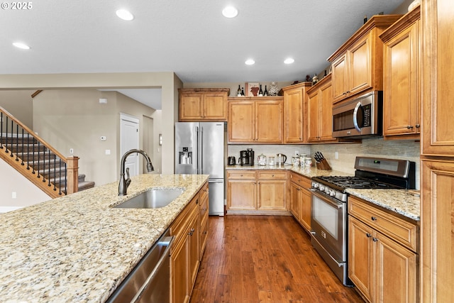 kitchen featuring dark wood-type flooring, sink, light stone counters, tasteful backsplash, and stainless steel appliances