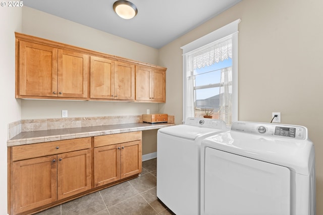 clothes washing area featuring cabinets, tile patterned flooring, and washer and clothes dryer