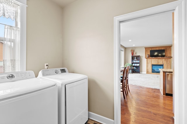 laundry room with hardwood / wood-style floors and washing machine and dryer