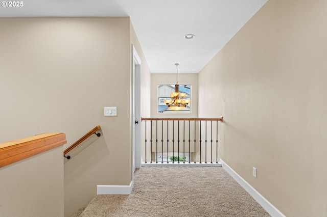 staircase featuring an inviting chandelier and carpet