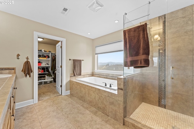 bathroom with independent shower and bath, vanity, and tile patterned floors