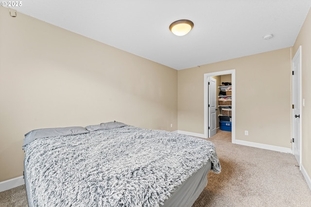 carpeted bedroom featuring a walk in closet and a closet