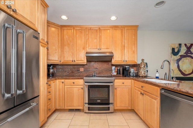 kitchen featuring dark stone counters, sink, decorative backsplash, light tile patterned floors, and stainless steel appliances