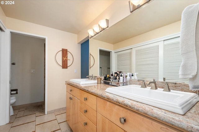 bathroom with tile patterned flooring, vanity, and toilet