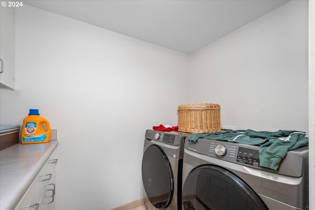 laundry room with cabinets and washer and dryer