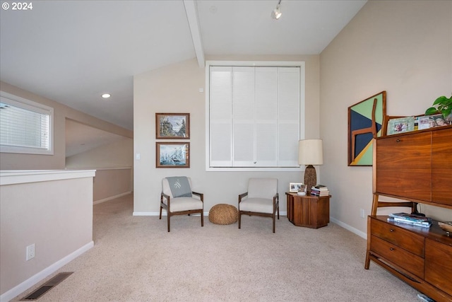 sitting room featuring lofted ceiling with beams and light colored carpet