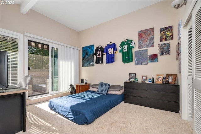 carpeted bedroom featuring beam ceiling and a closet