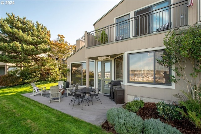 rear view of property with a lawn and a balcony