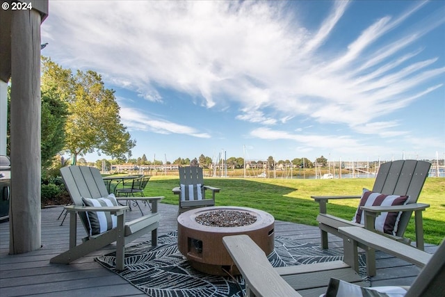 wooden terrace with a yard and an outdoor fire pit