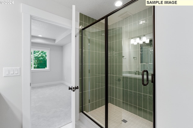 bathroom featuring a textured ceiling and walk in shower