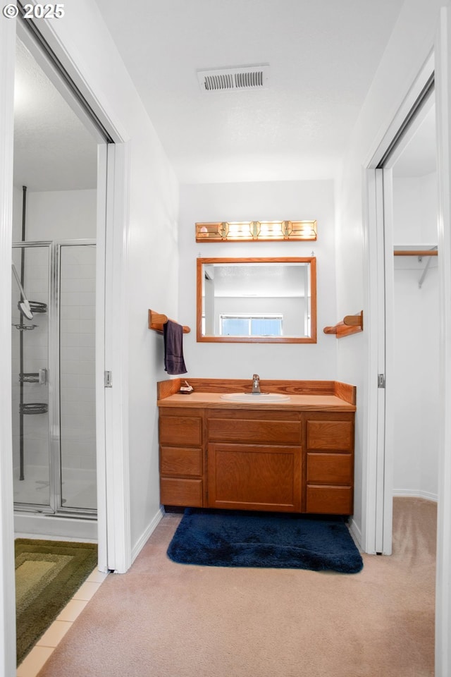 bathroom with vanity and a shower with door