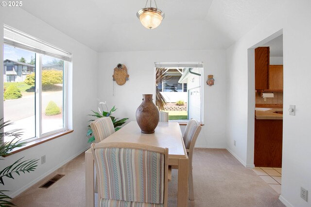 dining space featuring light carpet