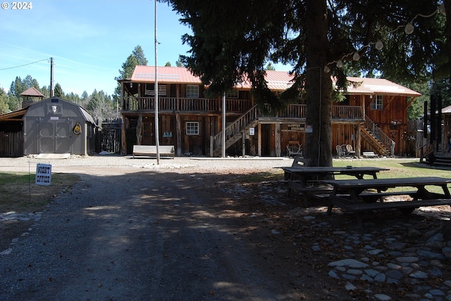 back of property with a deck and a shed