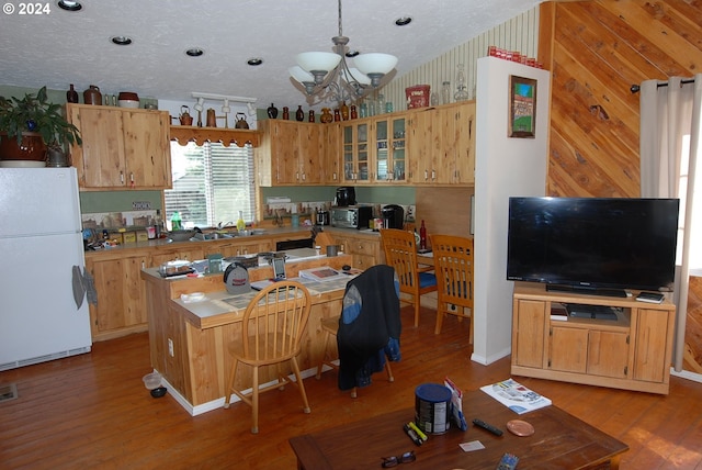 kitchen with white refrigerator, vaulted ceiling, light hardwood / wood-style floors, a textured ceiling, and an inviting chandelier